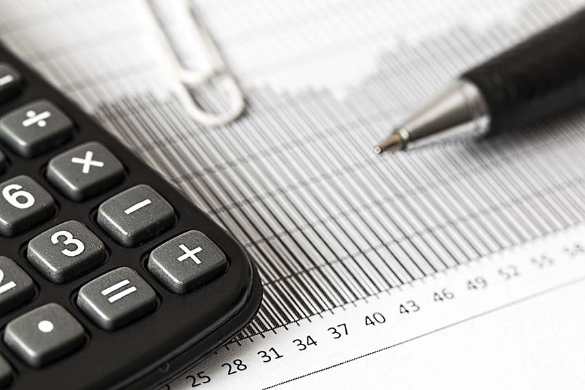 Una calculadora y un bolígrafo, sobre la hoja de un informe económico